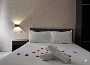 a bed with a bunch of red roses on it at Q Inn by Pillow Plus in Petaling Jaya