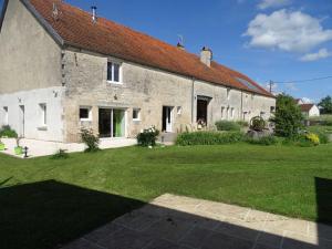 a large brick building with a grass yard at L'étable aux deux noix in Arc-en-Barrois