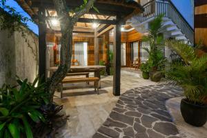 a patio with a wooden bench and some plants at Paisa Ubud in Ubud
