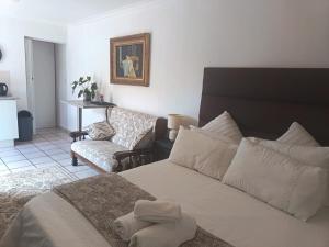 a living room with a bed and a couch at Isabel's B & B in Krugersdorp +49 photos