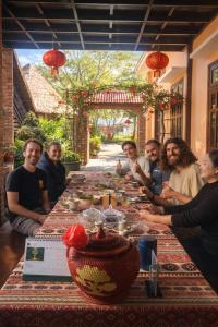 a group of people sitting around a long table at Ngọc Trâm Homestay in A Lưới (1)
