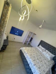 a bedroom with a bed and a chandelier at Ailynes in Diani Beach