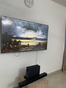 a painting hanging on a wall with a laptop on a table at Ailynes in Diani Beach +4 photos