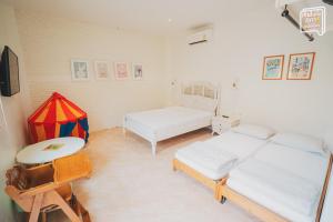 a room with two beds and a table in it at SATTAHIP Zentobu House in Ban Tao Than