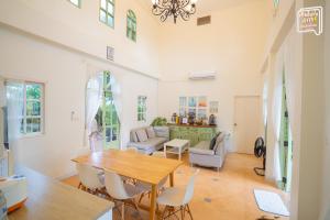 a living room with a wooden table and chairs at SATTAHIP Zentobu House in Ban Tao Than