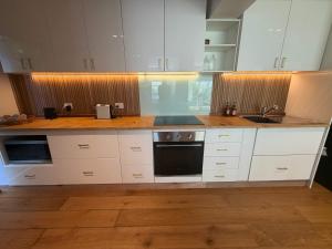 a kitchen with white cabinets and a sink at El Parche Bilinga Beachside, Unit 5, Sleeps 6 in Gold Coast