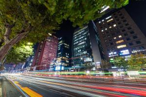 a busy city street at night with tall buildings at lazy tiger hotel in Seoul