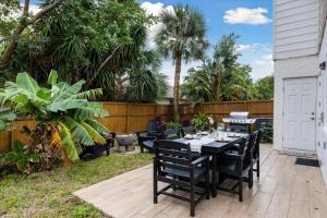a patio with black tables and chairs and palm trees at 10 Colonial Drive in Cocoa Beach