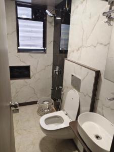 a bathroom with a toilet and a sink at Hotel Samarth Elite Baner - Indian Guests Only in Pune