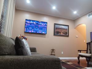 a living room with a couch and a tv on the wall at Nice Luxury Suite in Austell