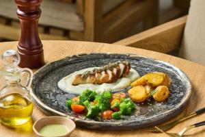 a plate of food with meat and vegetables on a table at Holistic EcoHotel in Santa Fe de Antioquia +50 photos