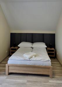 a bedroom with a large bed with white sheets and pillows at Domki Leśne Zacisze in Baczyn +35 photos