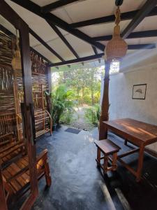 a room with a wooden table and a bench at LotusScape Ahangama in Ahangama