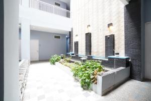 a hallway with benches and plants in a building at Kamar Bagus in Jakarta