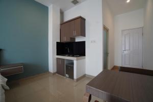 a room with a kitchen with a table and a microwave at Kamar Bagus in Jakarta