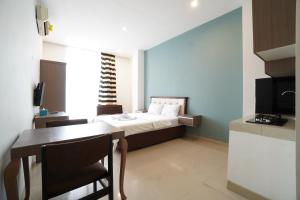 a small room with a bed and a dining table at Kamar Bagus in Jakarta