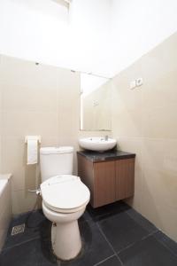 a white bathroom with a toilet and a sink at Kamar Bagus in Jakarta +8 photos