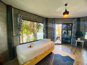 a bedroom with a bed and a large window at Family view A4 -Kantiang paradise resort- in Ko Bu Bu