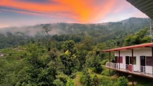 a rainbow over a mountain with a house at shiv shankar resort and hotel in Phata