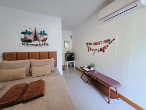 a bedroom with a large bed and a table at ไวท์ เฮ้าท์ แคมป์ ชะอม in Ban Bung Mai