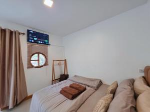 a living room with a couch and a flat screen tv at ไวท์ เฮ้าท์ แคมป์ ชะอม in Ban Bung Mai