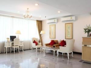 a living room with a couch and chairs and a desk at Romance Hotel Srinakarin in Bangkok