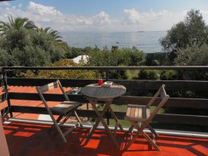 un tavolo e sedie su un balcone con vista sull'oceano di Ajò Faci a Mari a Capoterra