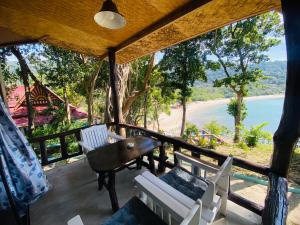 a porch with chairs and a table and a view of a beach at Family view A4 -Kantiang paradise resort- in Ko Bu Bu