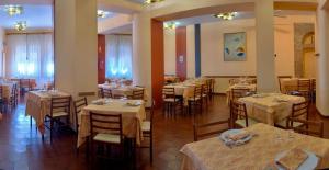 un ristorante con tavoli e sedie in una stanza di Hotel Giardinetto a Loreto