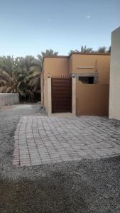 a building with a garage with a brick driveway at Quriyat in Afā