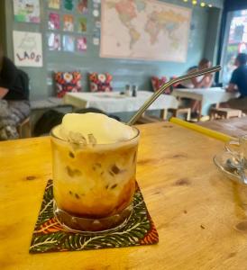 a drink sitting on top of a wooden table at Over the Moon hostel in Ban Houayxay