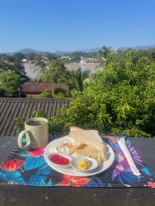 a plate of breakfast food and a cup of coffee at Over the Moon hostel in Ban Houayxay