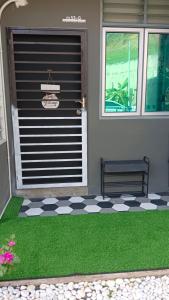 a front door of a house with green grass at MiniHaus2Stay in Pulau Sebang