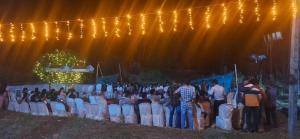 a group of people sitting in chairs under lights at Jackroot Heritage wood villa Athirappilly in Kallana