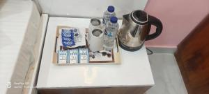 a small white table with a coffee maker and drinks on it at The KP RESORT in Chīrgaon