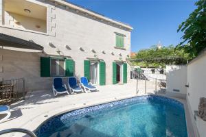 a house with a swimming pool next to a building at Villa Angelina in Mirce
