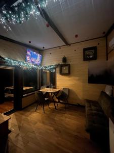 a room with a table and chairs and a tv at Nagoru house in Tukhlya