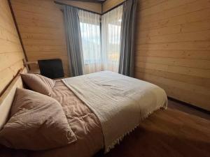 a bedroom with a bed in a room with a window at Nagoru house in Tukhlya +18 photos