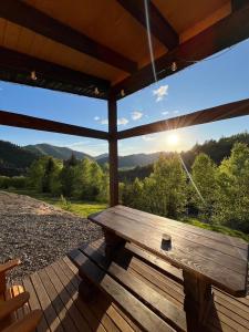 a wooden bench on a porch with a view of the mountains at Nagoru house in Tukhlya