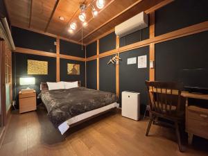 a bedroom with a bed and a desk and a television at 倉敷ながや Kurashiki Nagaya 美観地区徒歩4分 一棟貸切 無料駐車場あり 最大9名 in Kurashiki