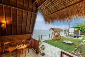 a porch of a resort with a table and chairs at La Semaya Beach Villas in Nusa Penida +36 photos