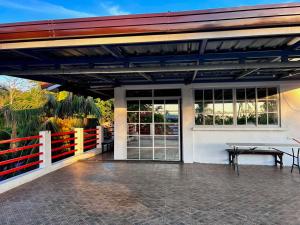 a patio with a table and a fence at KNB West Villa Inn by SMS Hospitality in Bolinao