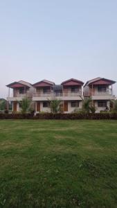 a row of houses in a field of grass at Shri Balaji Resort in Ellora