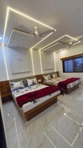 a bedroom with two beds and a ceiling at Shri Balaji Resort in Ellora