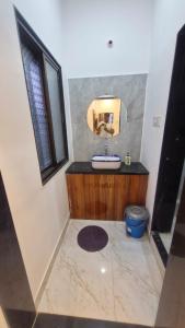 a bathroom with a sink and a mirror at Shri Balaji Resort in Ellora +4 photos