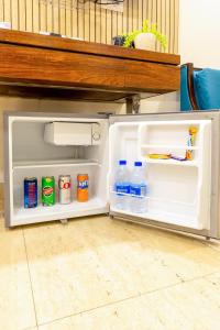 an open refrigerator with bottles of milk and water at Hotel Neu Villa, City Centre - Near Connaught Place & NDLS Station in New Delhi