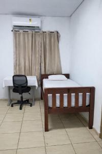 a room with a bed and a desk and a chair at Pousada RC Q3 in Várzea Grande