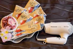a hair dryer and flowers on a table at Osaka - Hotel / Vacation STAY 65254 in Osaka