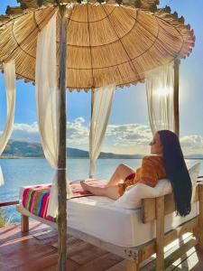 a woman laying on a bed under an umbrella at Titicaca Samay Lodge Perú in Puno +8 photos
