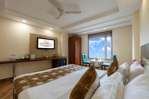 a hotel room with a bed and a television at Hotel Neu Villa, City Centre - Near Connaught Place & NDLS Station in New Delhi +65 photos